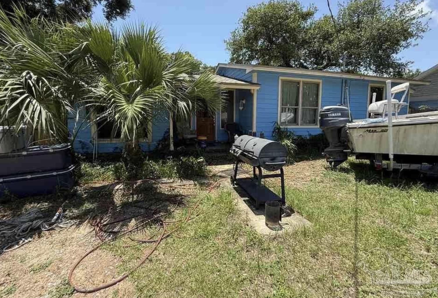 Blue ranch home with palm trees