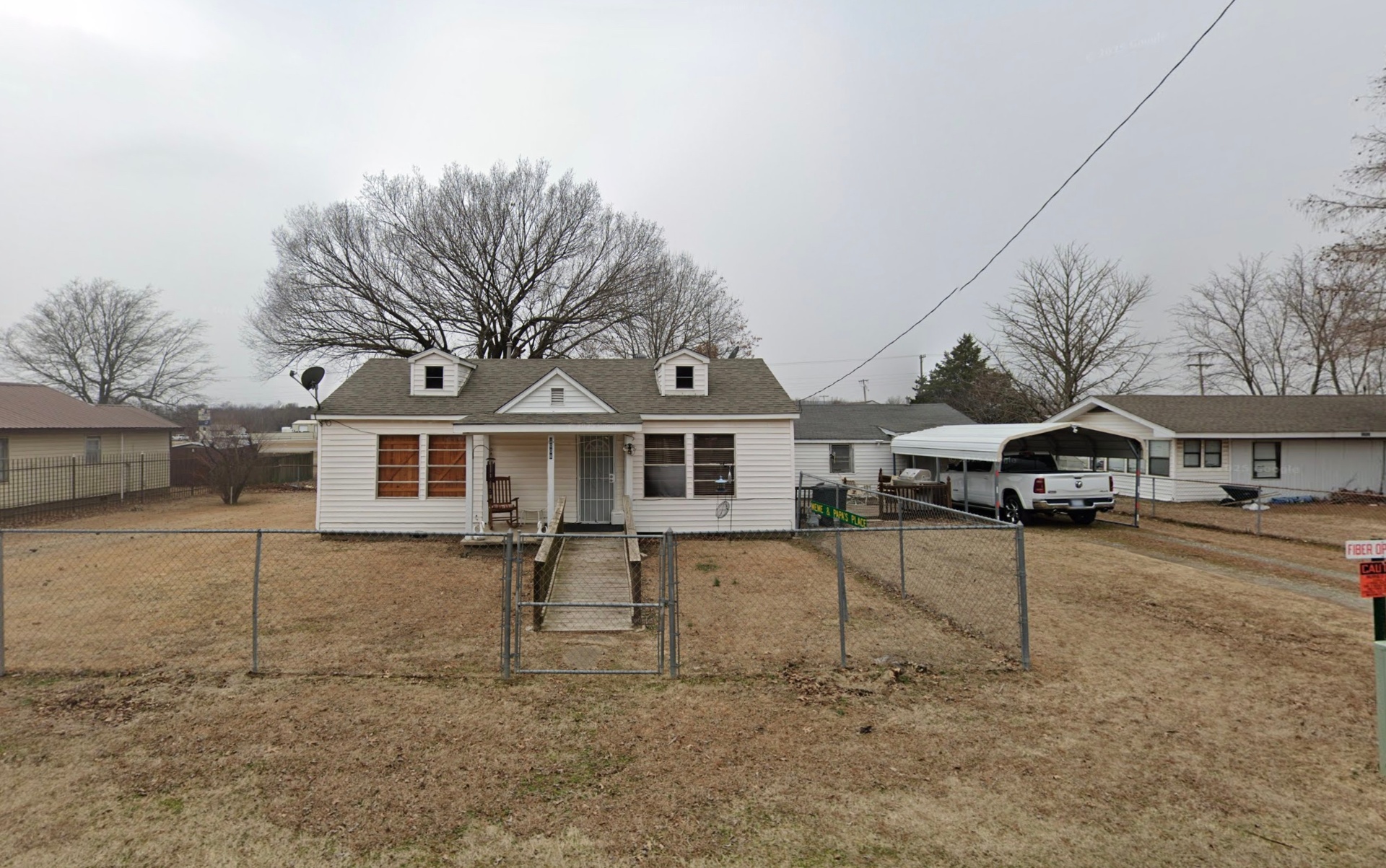 Cape Cod style home with chain-link fence