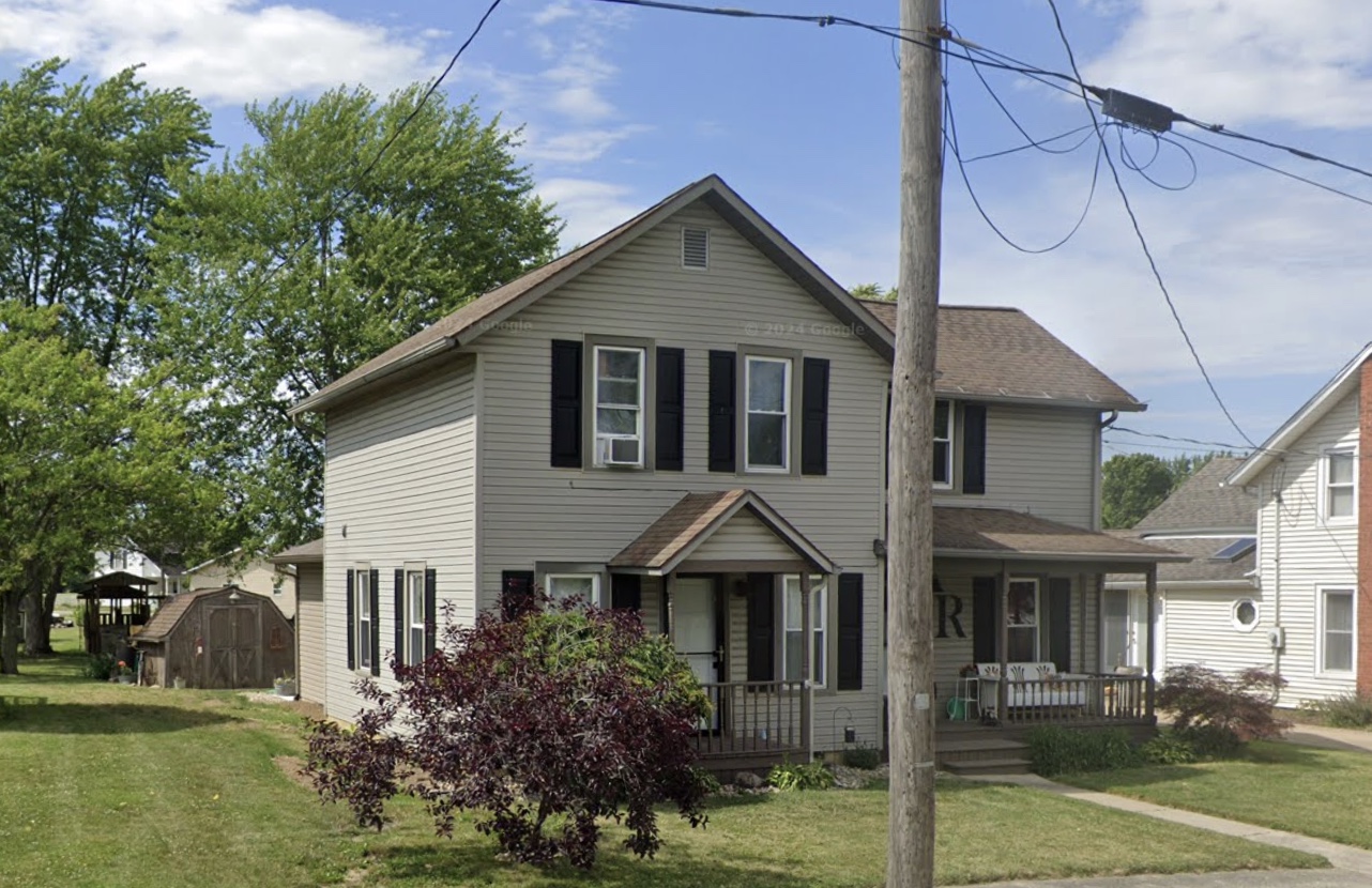 Two-story home with black shutters and front porch