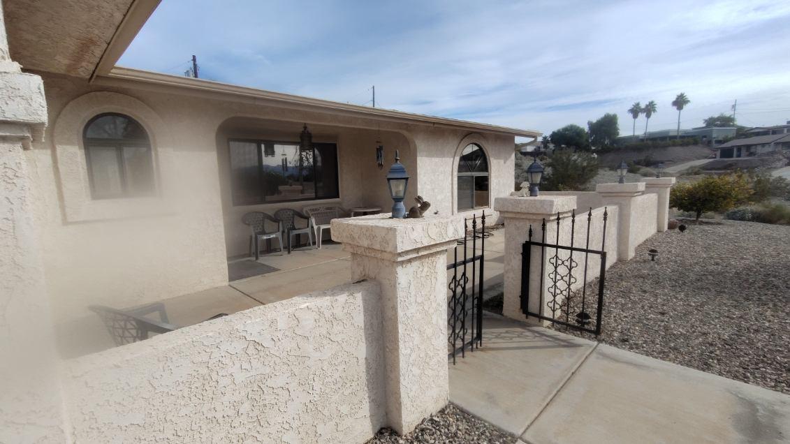 Stucco ranch home with arched windows and iron gate