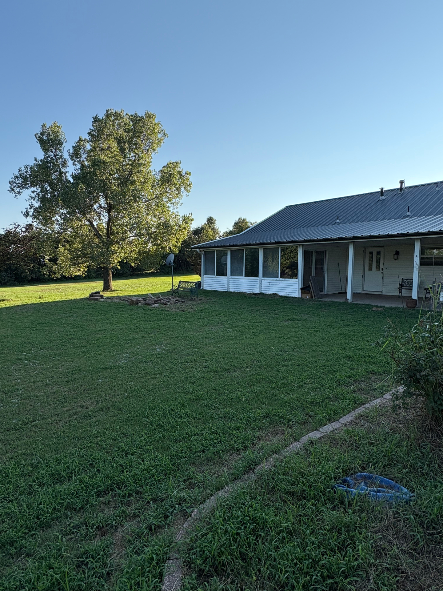 Country farmhouse with metal roof and screened porch